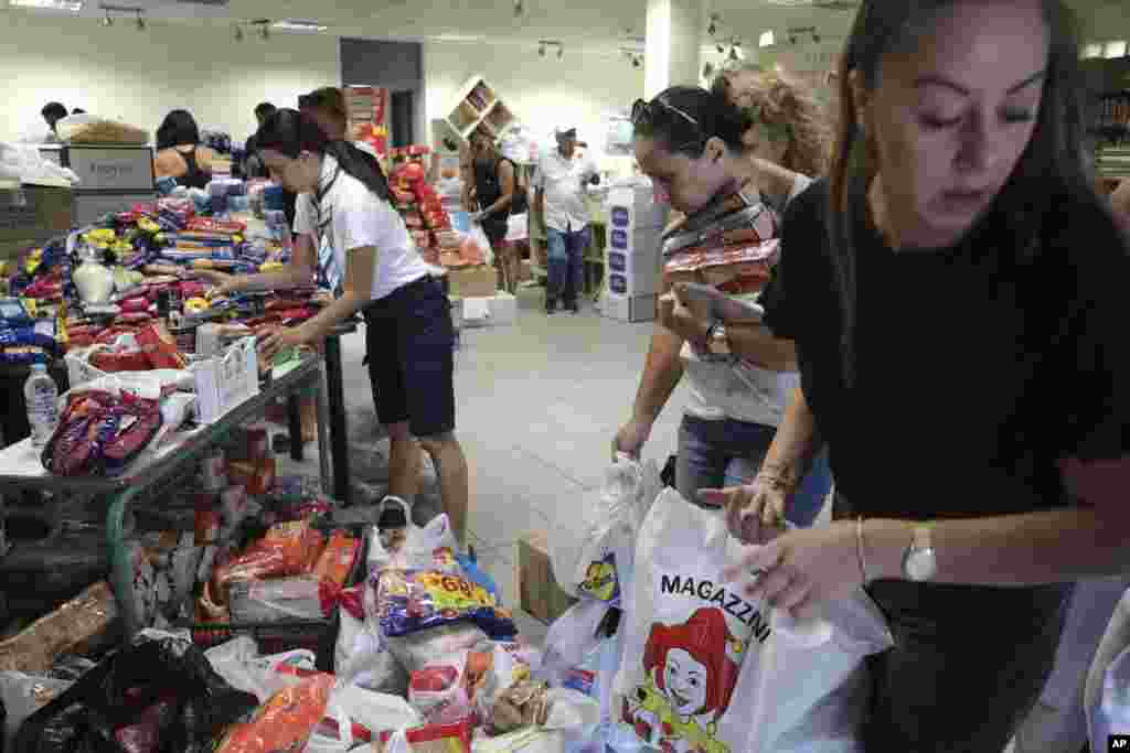 People sort supplies for residents rescued from the wildfire in the village of Nea Makri near Athens, Tuesday, July 24, 2018. 