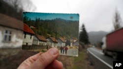 In this photo taken on Jan. 23, 2020, an old postcard shows how the village of Blagojev Kamen, Serbia, looked like fifty years ago.
