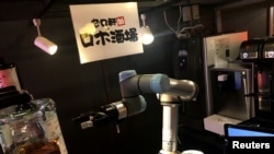 A robot bartender moves its arm to make a cocktail at a Japanese pub operated by restaurant chain Yoronotaki in Tokyo, Jan. 29, 2020. 