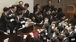 National Assembly Vice Speaker Chung Eui-hwa, second from left top, wearing glasses, declares the passage of a bill on ratification of a South Korea-U.S. free trade agreement as opposition lawmakers try to stop it at the National Assembly in Seoul, South 