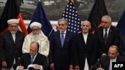 Avganistanski savetnik za nacionalnu bezbednost Hanif Atmar i američki ambasador u Avganistanu Džejms Kaningem potpisuju sporazum o bezbednosti u prisustvu najviših avganistanskih zvaničnika