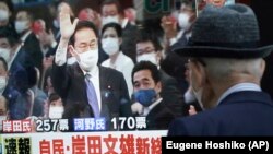 Un piéton regarde la victoire de Fumio Kishida à la télévision après un vote du parti au pouvoir au Japon, mercredi 29 septembre 2021, à Tokyo.