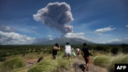 A plume of ash is released as Mount Agung volcano erupts, seen from the Kubu subdistrict in Karangasem Regency on Indonesia's resort island of Bali on May 31, 2019.