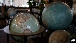 Various size of globes are displayed at a studio in London, Tuesday, Feb. 27, 2024. Globes in the age of Google Earth capture the imagination and serve as snapshots of how the owners see the world and their place in it. (AP Photo/Kin Cheung)