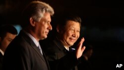 El presidente de China, Xi Jinping, saluda a la prensa acompañado por el vice presidente de Cuba, Miguel Díaz-Canel, a su llegada al país.