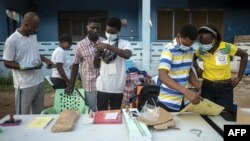 Les agents de la commission électorale font les derniers préparatifs de l'élection présidentielle et parlementaire dans un bureau de vote en plein air, à Accra, le 7 décembre 2020. CRISTINA ALDEHUELA / AFP