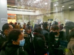 People queue for receiving treatment at the fever outpatient department at the Wuhan Tongji Hospital in Wuhan, Hubei province, China, Jan. 22, 2020.