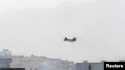 A CH-46 Sea Knight military transport helicopter flies over Kabul, Afghanistan, Aug. 15, 2021.