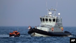 Sebuah Kapal Penjaga Perbatasan Inggris membantu sekelompok migran yang terapung-apung di atas perahu karet mereka di perairan Selat Inggris.