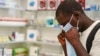Un homme essaye un masque de protection dans une pharmacie à Kitwe en Zambie le 6 février 2020.