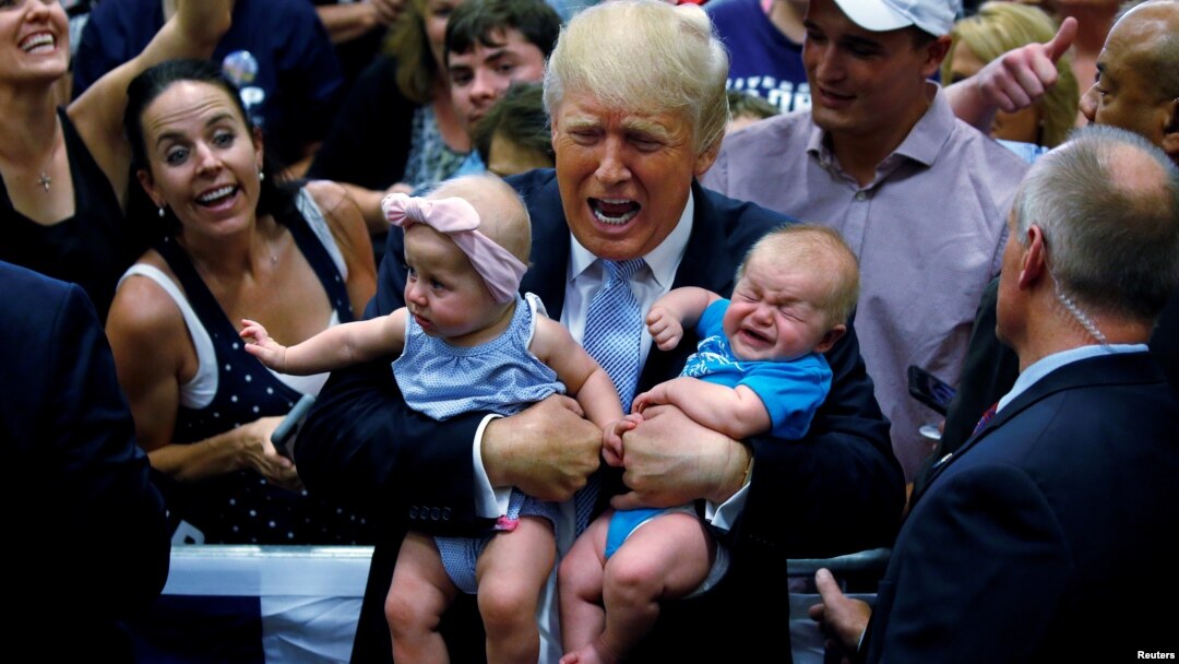 Ông Trump, khi còn là ứng cử viên tổng thống, bế 2 em bé ở Colorado, 29/7/2016 (REUTERS/Carlo Allegri).