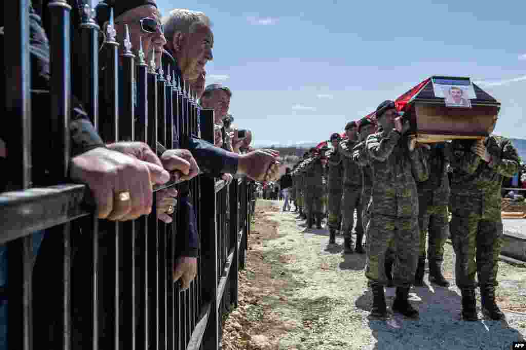 Những thành viên của lực lượng an ninh Kosovo mang quan tài chứa di hài của 21 người Albania ở Kosovo được cho là bị lực lượng an ninh Serbia giết hại trong cuộc chiến Kosovo 1998-1999, trong một buổi lễ mai táng tại làng Qikatove. Những di hài được xác định sau khi được khai quật từ một ngôi mộ tập thể ở Serbia.