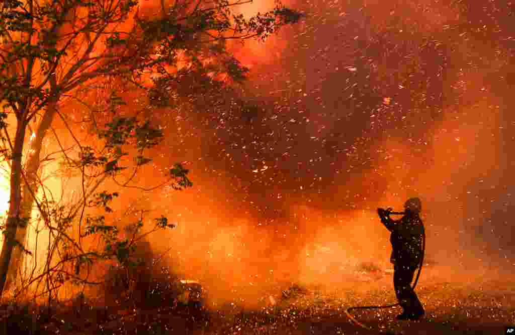 A firefighter battles flames in Cordoba, Argentina, Oct. 12, 2020. Wildfires have destroyed thousands of hectares in the Argentine province of Cordoba this year, amid a drought and high temperatures.