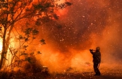 FILE - A firefighter battles flames in Cordoba, Argentina, Oct. 12, 2020. Wildfires have destroyed thousands of hectares in the Argentine province of Cordoba this year, amid a drought and high temperatures.