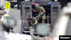 A Turkish army tank drives in front of the ruins of Kobani (seen in the background) near the Turkish-Syrian border, Oct. 24, 2014.
