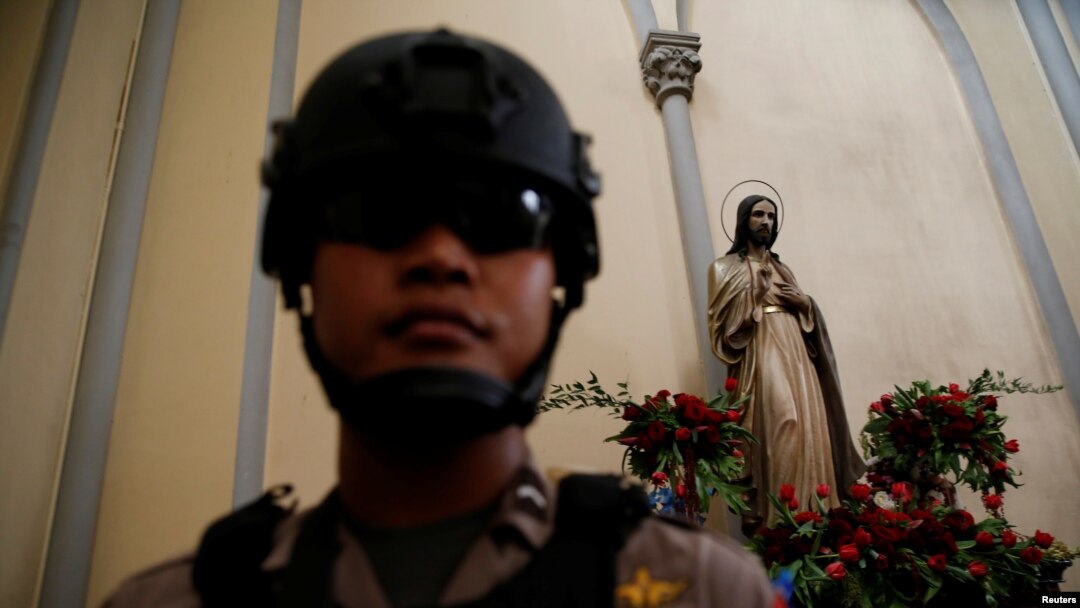 Seorang polisi di dalam Gereja Katedral Jakarta untuk memeriksa keamanan menjelang perayaan natal, Jakarta, 24 Desember 2016. (Foto:Dok)