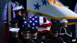 The flag-draped casket of former Secretary of State Colin Powell is carried into the Washington National Cathedral for a funeral service in Washington.