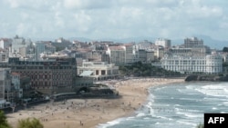 People swim in the sea and walk on the beach in Biarritz, on Aug. 13, 2019. 