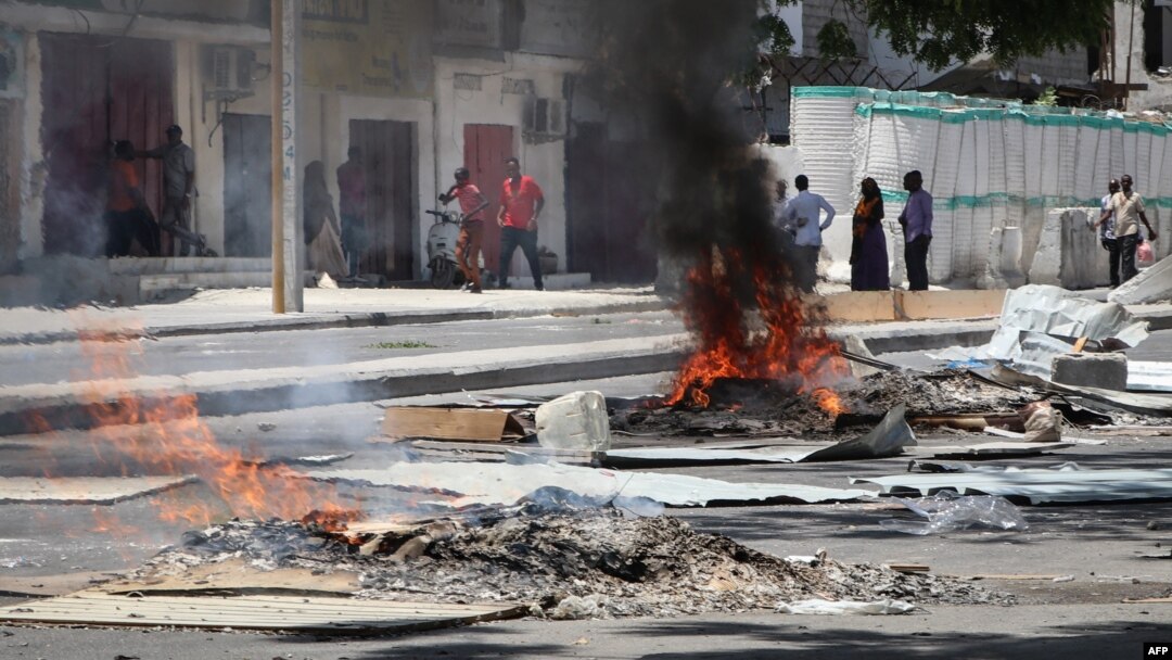 Kebakaran-kebakaran di jalan menyusul penembakan seorang sopir tuktuk dan penumpangnya, 13 April 2019, di Mogadishu.