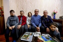 From left: Adil Sharifov's grandson Ramazan Sharifov, uncle Ramiz Humbatov, sister Kamala Sharifova, Adil Sharifov, his mother Adila Ahmadova and grandson Tariyel Sharifov pose for a photo at home in Baku, Azerbaijan, Nov. 20, 2020.