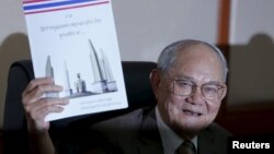 Meechai Ruchupan, head of Thailand's Constitution Drafting Committee, holds up a draft constitution during a news conference at the parliament in Bangkok, Thailand on March 29, 2016. 