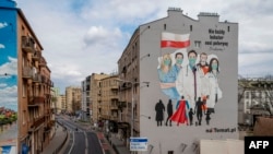 FILE - A mural paying tribute to the sacrifice of doctors, nurses and paramedics in the fight against the coronavirus is seen in Warsaw, Poland, April 2, 2020.