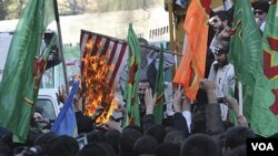 Peserta demo di depan bekas Kedubes AS di Teheran membakar bendera Amerika, Jumat (4/11) dalam aksi protes tahunan memperingati pendudukan Kedubes AS di tahun 1979.