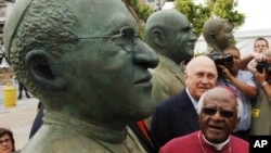 L’ancien lauréat du prix Nobel, Desmond Tutu, avant-plan, et l'ancien président sud-africain FW de Klerk, arrière-plan, regardent des statues faites à leur visage lors d'une cérémonie de dévoilement au Cap, Afrique du Sud, 16 décembre 2005.