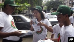 ရန်ကုန်မြို့ လမ်းမတွေပေါ်မှာ ရွေးကောက်ပွဲ မဲဆွယ်စည်းရုံး လှုပ်ရှားနေကြသည့် ကြံ့ခိုင်ဖွံ့ဖြိုးရေး ပါတီဝင်တချို့ (အောက်တိုဘာလ ၉၊ ၂၀၁၀)