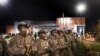 FILE - Members of the National Guard stand guard outside the Ferguson Police Department where demonstrators gathered to protest the shooting of Michael Brown in Ferguson, Mo., Nov. 28, 2014. 