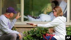 FILE - Senior citizens at assisted living facilities are often at higher risk of suffering from loneliness. Here, Judie Shape (center) blows a kiss to her son-in-law and daughter at the Life Care Center in Washington state in the U.S., March 11, 2020. (File Photo)