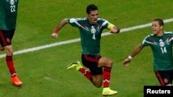 Le Mexicain Rafael Marquez, au centre, célèbre ses coéquipiers Paul Aguilar et Javier Hernandez après avoir marqué le premier but de son équipe contre la Croatie à l'arène de Pernambuo à Recife le 23 juin 2014.c