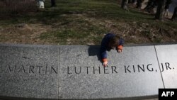 Dijete dotiče ime Martina Luthera Kinga Jr. na njegovom spomeniku dan uoči Dana Martina Luthera Kinga Jr. u Washingtonu, D.C., 14. januara 2024.