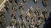 FILE - Myanmar soldiers walk along a street during a protest against the military coup in Yangon, Myanmar, Feb. 28, 2021.