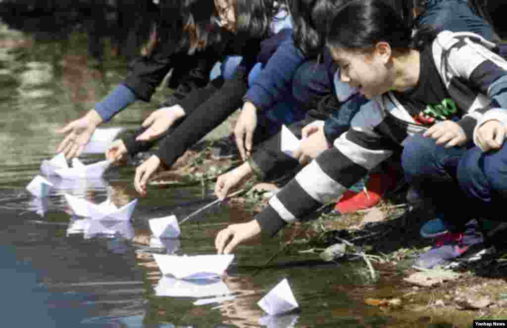 26일 한국 춘천시 이디오피아한국전참전기념관 앞에서 열린 '천안함 피격 사건 3주기 추모식'에서 신남초등학교 학생들이 직접 쓴 추모 편지를 종이배로 접어 공지천에 띄워 보내고 있다.