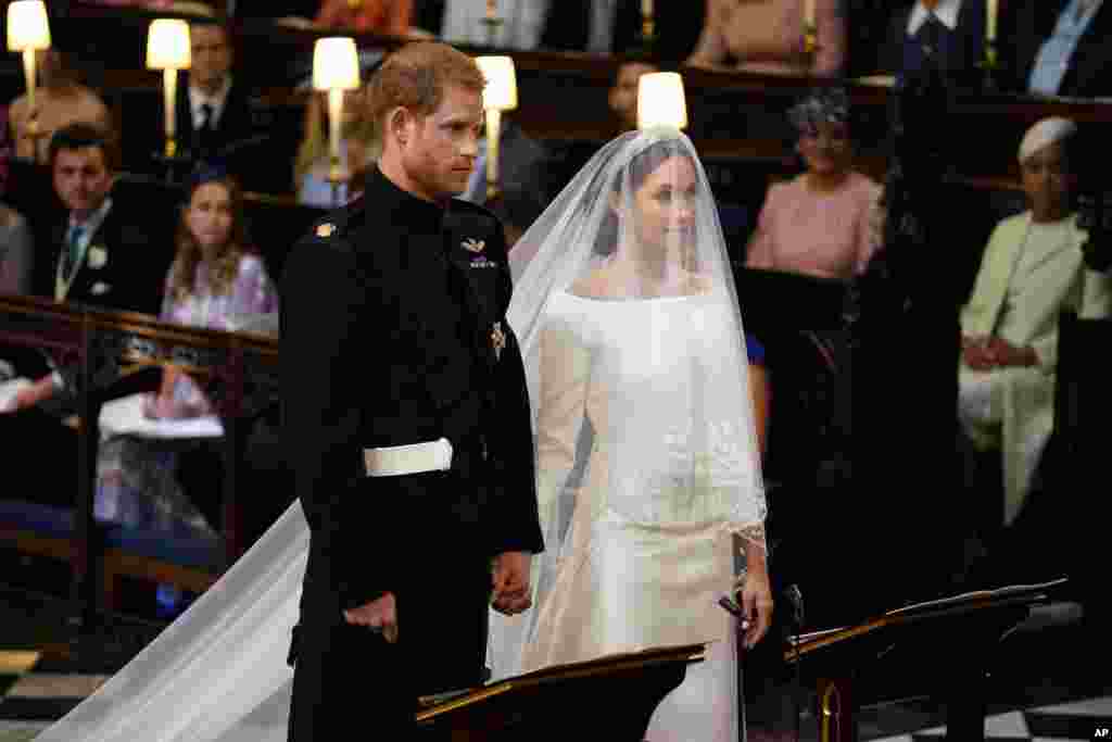 Pangeran Inggris Harry dan Meghan Markle berdiri, menjelang dimulainya prosesi pernikahan mereka di Kapel Santo George,&nbsp;Istana Windsor,&nbsp;dekat London, Inggris, 19 Mei 2018.&nbsp;