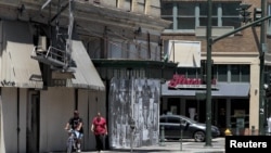 People walk past shuttered businesses in downtown Stockton, California