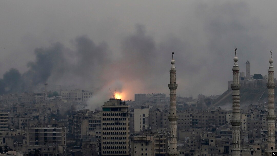 Bola api terlihat di kawasan timur Aleppo, Suriah, menyusul serangan udara yang menghantam wilayah itu (5/12). (AP/Hassan Ammar)