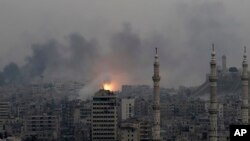 Bola api terlihat di kawasan timur Aleppo, Suriah, menyusul serangan udara yang menghantam wilayah itu (5/12). (AP/Hassan Ammar)