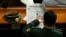 FILE - A military delegate reads a China Daily newspaper ahead of the second plenary session of the National People's Congress (NPC) in Beijing, March 9, 2009. 