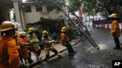 Para petugas membersihkan jalanan dari pohon tumbang akibat terpaan topan Vicente di Hong Kong (24/7).