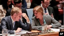 Britain's U.N. Ambassador Matthew Rycroft, left, and United States U.N. Ambassador Samantha Power, right, confer during a Security Council meeting on terrorism, May 11, 2016, at U. N. headquarters in New York.