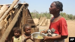 Toharano, une mère de 18 enfants se tient avec deux d'entre eux dans le village d'Ankilimarovahatsy, à Madagascar, le 9 novembre 2020.