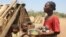 Toharano, une mère de 18 enfants se tient avec deux d'entre eux dans le village d'Ankilimarovahatsy, à Madagascar, le 9 novembre 2020.
