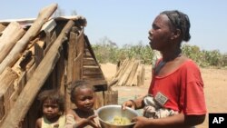 Toharano, mother of 18 children, with two of her children, holds a bowl in the village of Ankilimarovahatsy, Madagascar, Nov. 9, 2020.