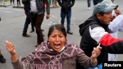 A woman reacts during clashes between supporters of former Bolivian President Evo Morales and members of the security forces, in La Paz, Bolivia, Nov. 13, 2019.
