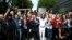 United Kingdom, The Beatles cover band members pose for a photograph with fans on the zebra crossing on Abbey Road in London