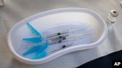 Syringes and a vial of AstraZeneca vaccine against COVID-19 sit on a general practitioners' table during a vaccination campaign in Amsterdam, Netherlands, Wednesday, April 14, 2021. (AP Photo/Peter Dejong)