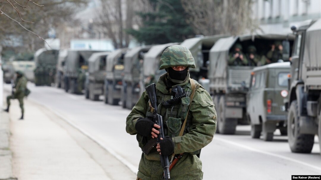 Prajurit bersenjata menunggu di kendaraan tentara Rusia di luar pos penjaga perbatasan Ukraina di Kota Krimea Balaclava, 1 Maret 2014. (Foto: REUTERS/Baz Ratner)