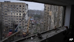 Nhân viên cứu hộ dọn dẹp đống đổ nát tại một tòa nhà chung cư đã bị phá hủy trong một cuộc tấn công bằng phi đạn của Nga vào một khu dân cư ở thành phố Dnipro, đông nam Ukraine, ngày 16 tháng 1 năm 2023.